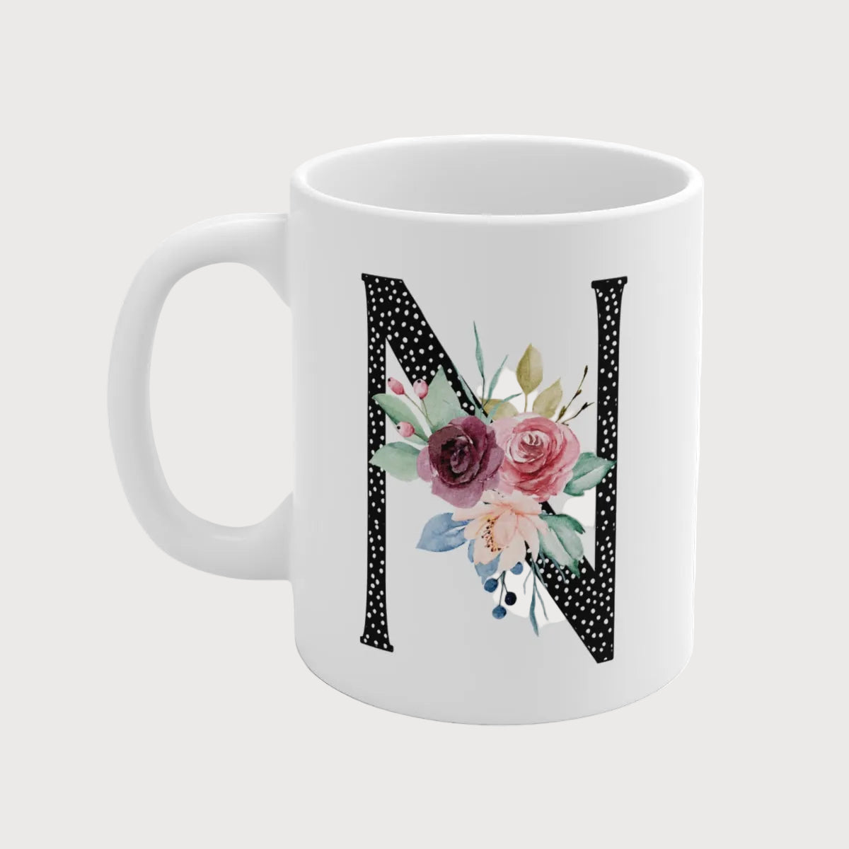 White mug with floral letter 'N' design on a white background