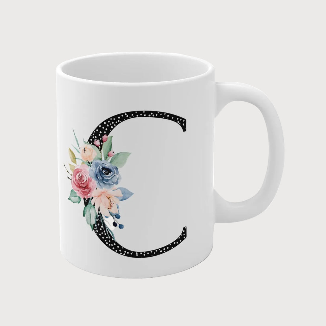 White mug with floral letter 'W' design on a white background