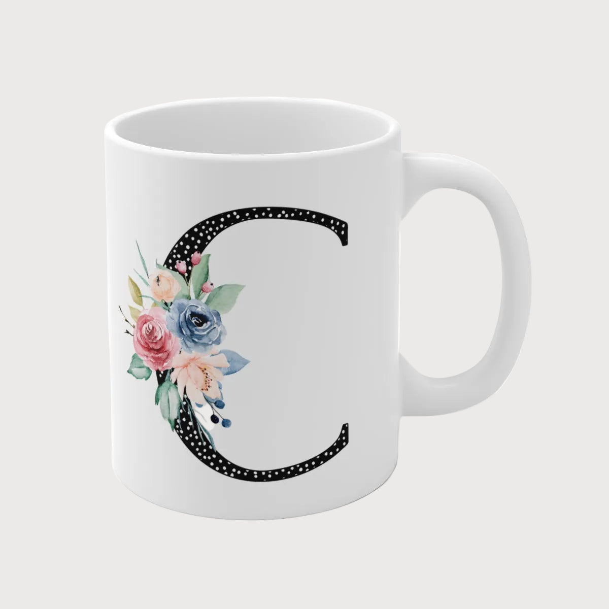 White mug with floral letter 'C' design on a white background