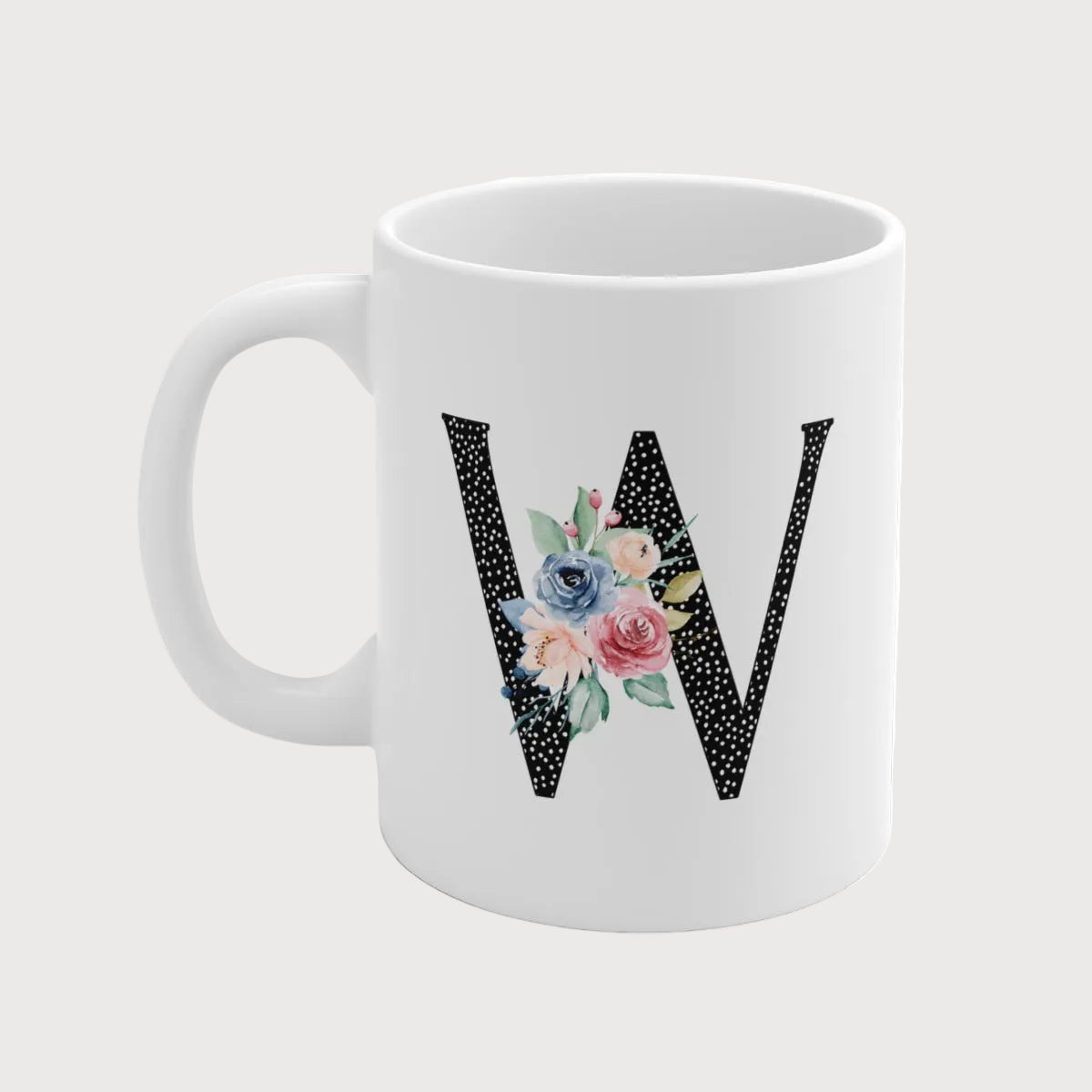 White mug with floral letter 'W' design on a white background