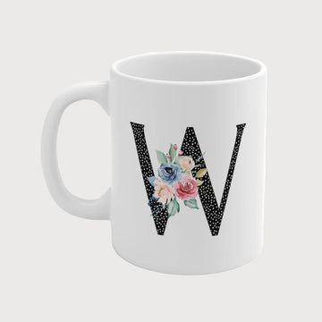 White mug with floral letter 'W' design on a white background