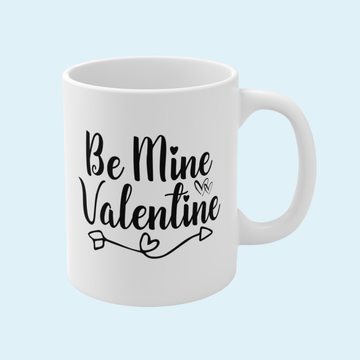 White mug with 'Be Mine Valentine' text on a light blue background