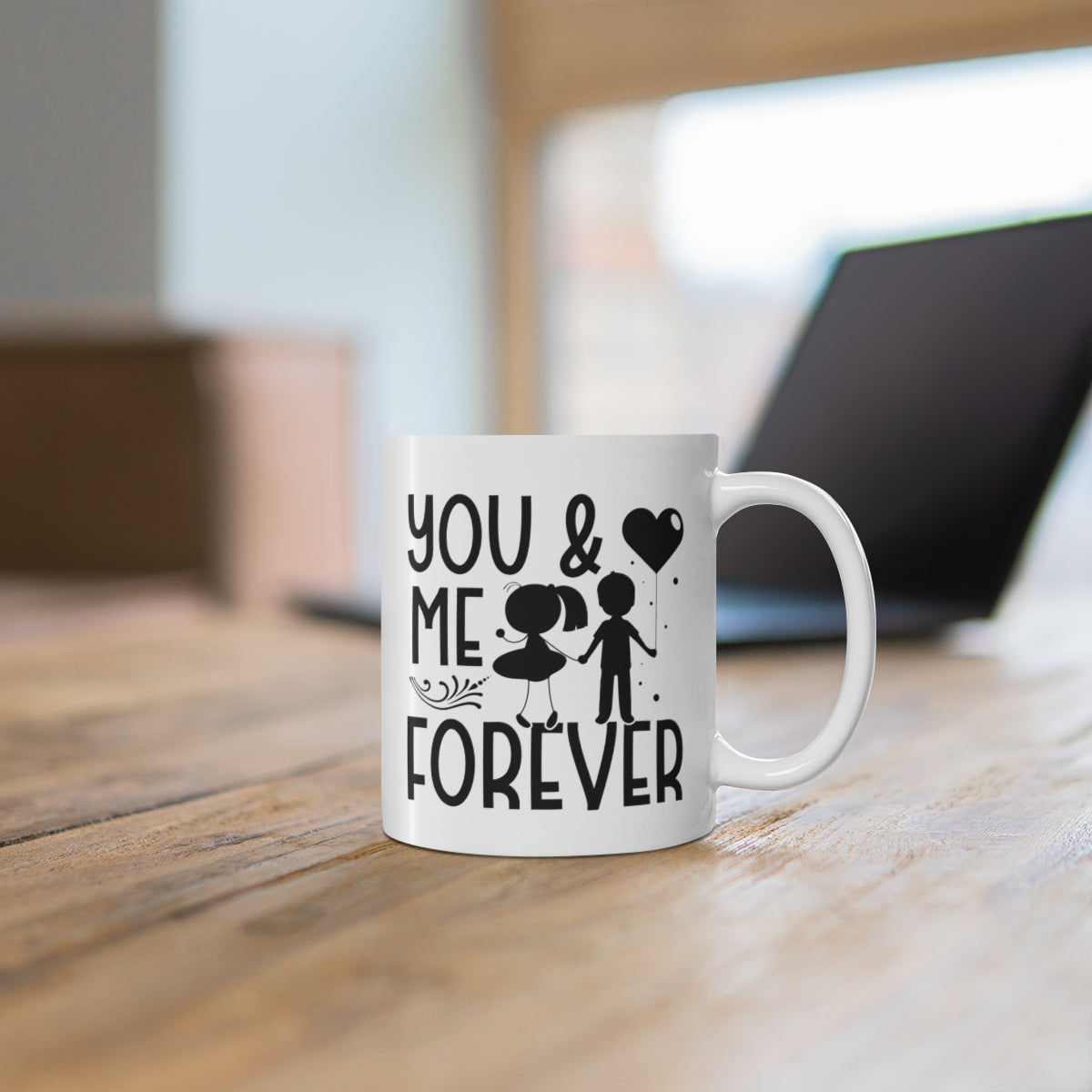 White mug with 'You & Me Forever' text and graphics on a wooden surface.