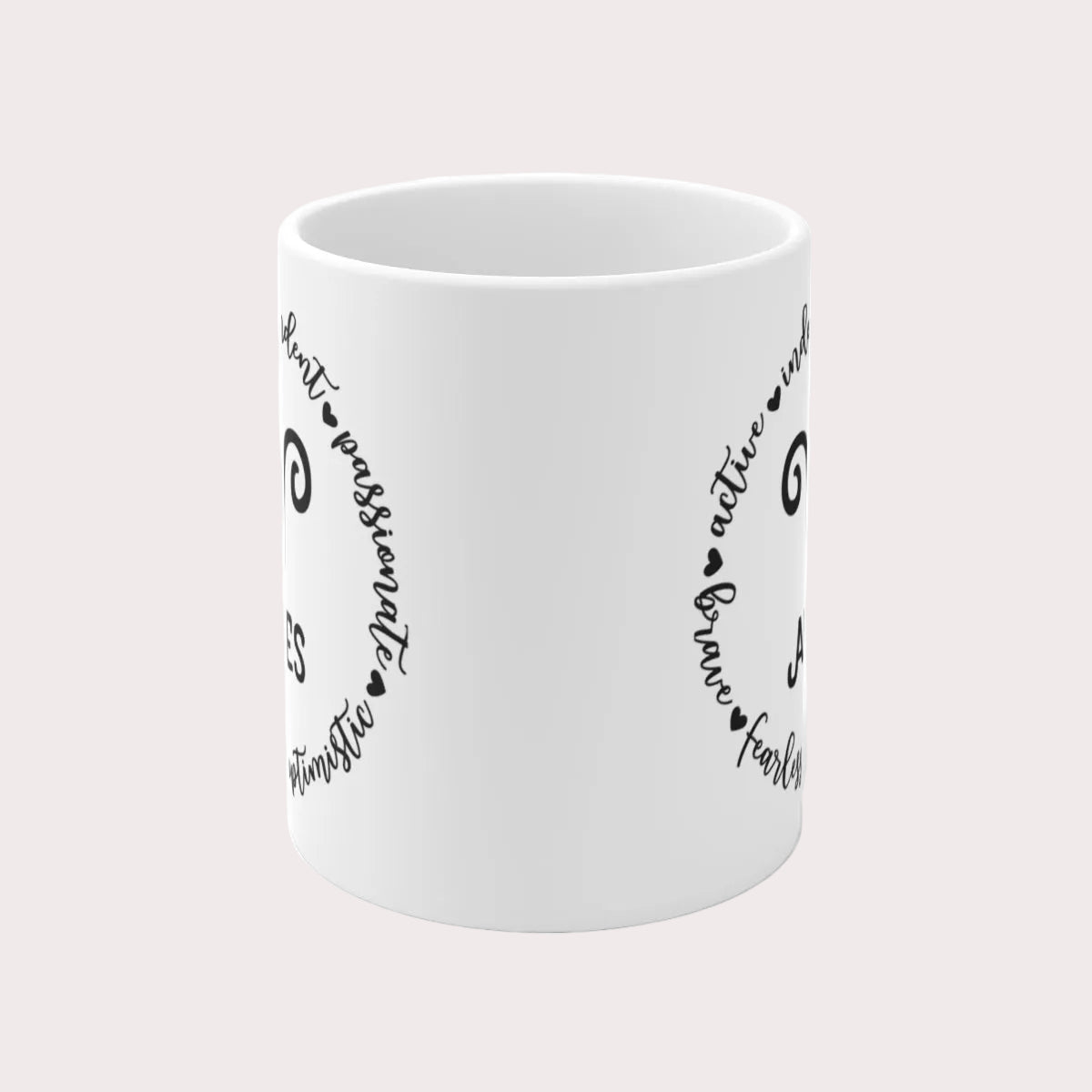 White mug with black text and heart designs on a light gray background