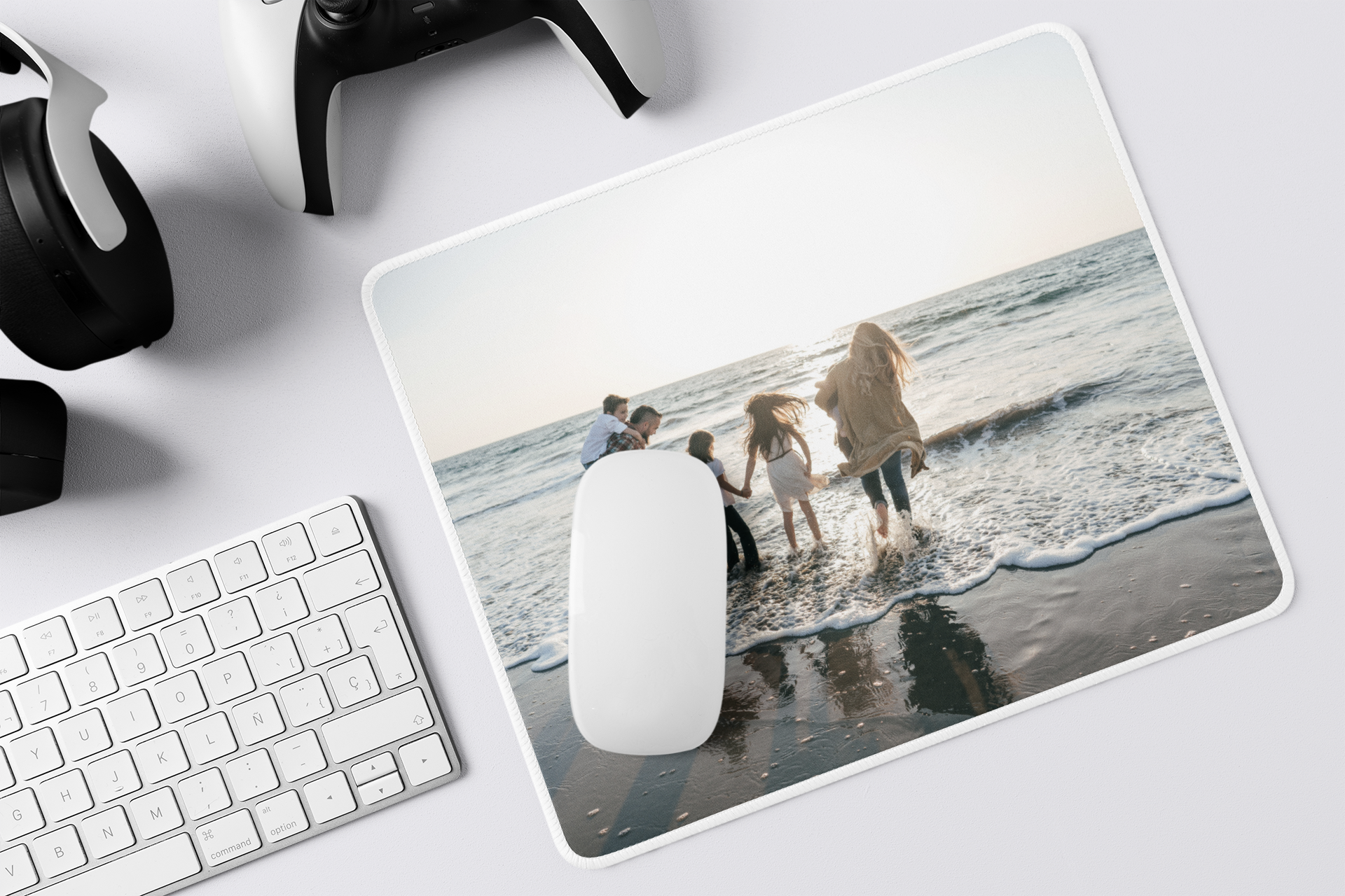 Mouse pad with a beach scene design on a desk with a keyboard and headphones.