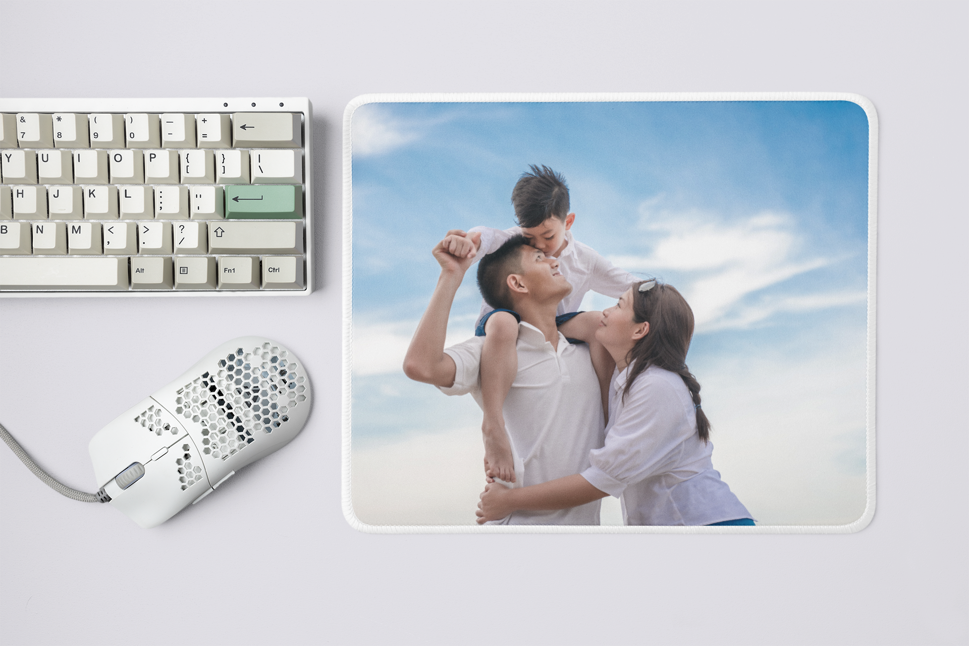 Mouse pad with a family photo on a desk with a keyboard and mouse. 